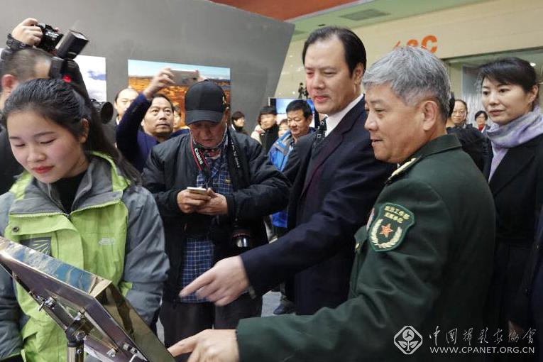中国文联党组成员、副主席、书记处书记李前光（右三）在展览现场查看最佳拍摄点实例。.jpg