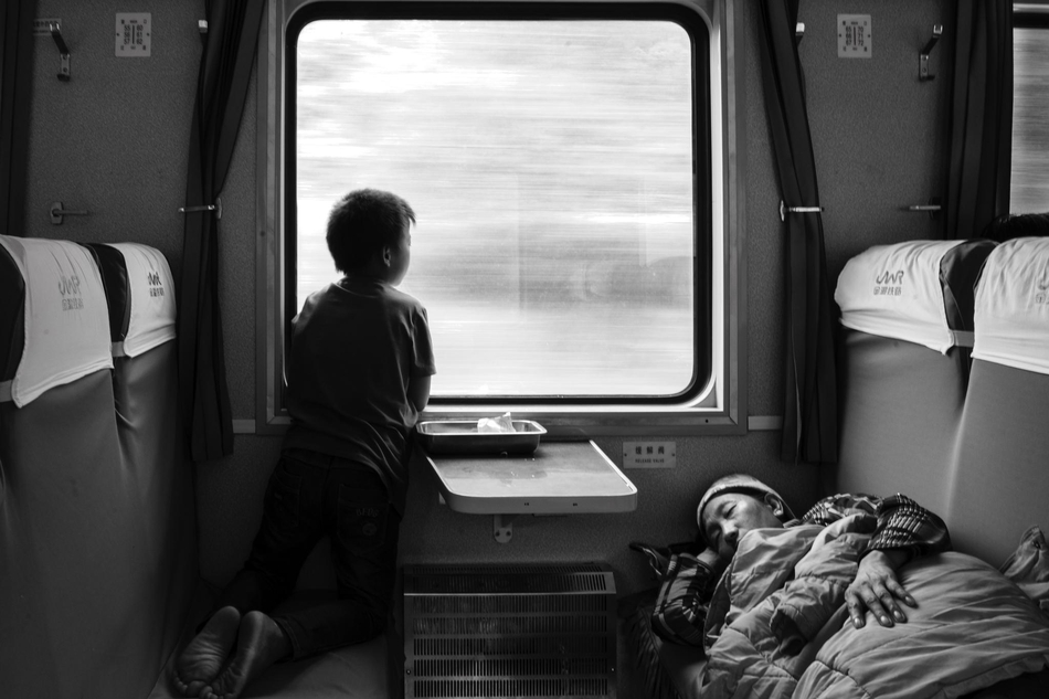 《远行的孩子》 来自图虫网投稿：@MrChina 火车上有许多边远贫困地区到发达地区打工的农民工，高铁动车的长途票价他们无力负担。已辍学的孩子安静地看着窗外很久，一反之前的顽皮，在想些什么？他什么也没说。.jpg