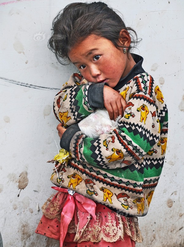 《抱鸡的小姑娘》摄影：@上山下乡66 家养的鸡到集市上的卖，以换取经济来源，小姑娘舍不得地紧抱着自家的鸡。 2014年6月摄于西昌昭觉。来自 一个都不能少 中国扶贫公益摄影大赛.jpg